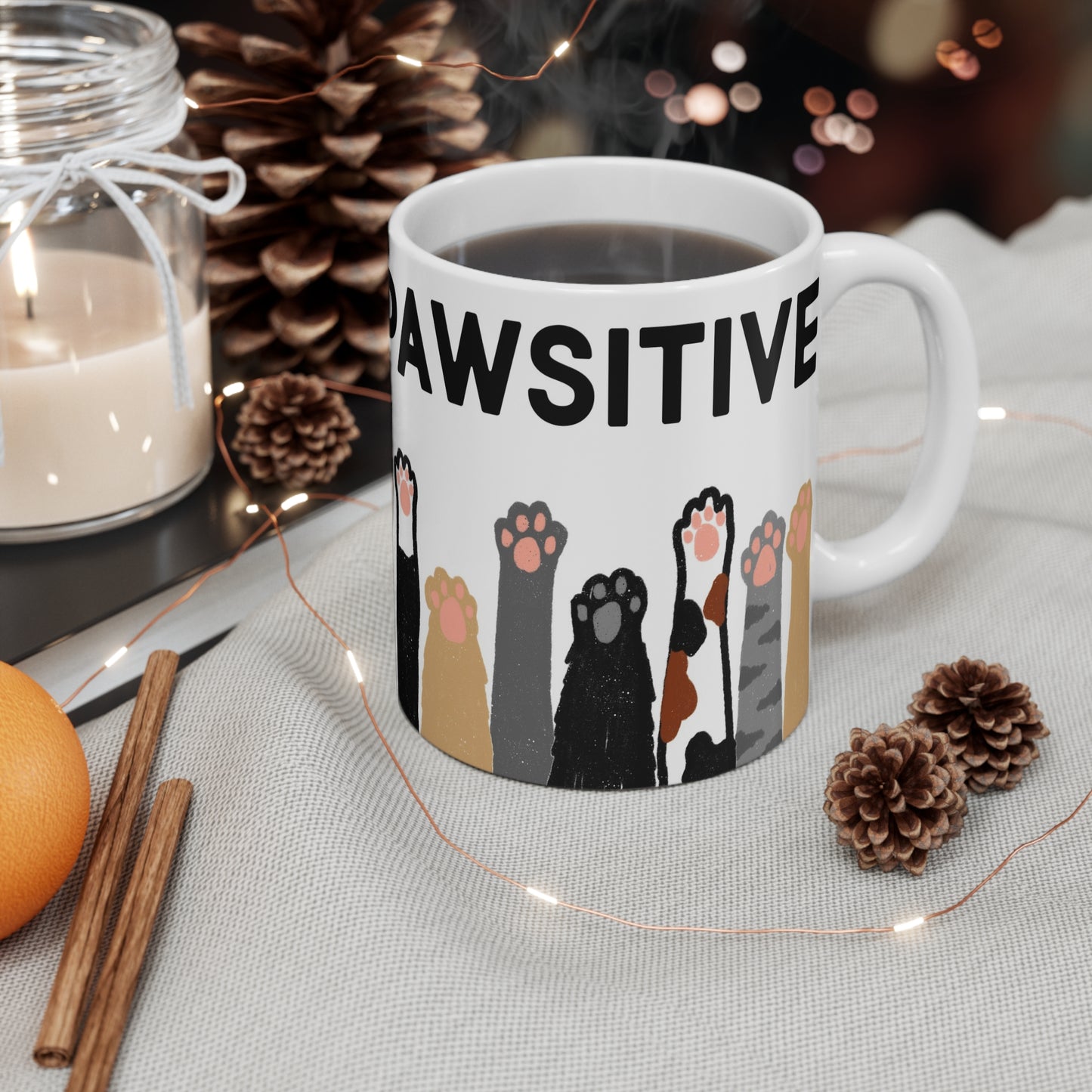 White ceramic mug with illustrated cat paws in various colors and the phrase “Always Pawsitive” around the top.