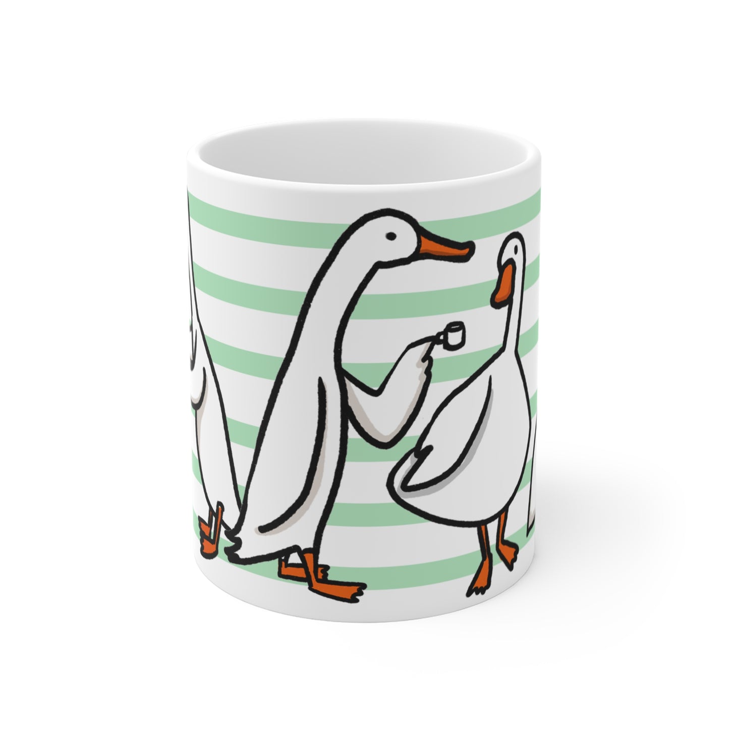 White ceramic mug featuring illustrated ducks drinking coffee, holding mugs, and sharing croissants on a green striped background.