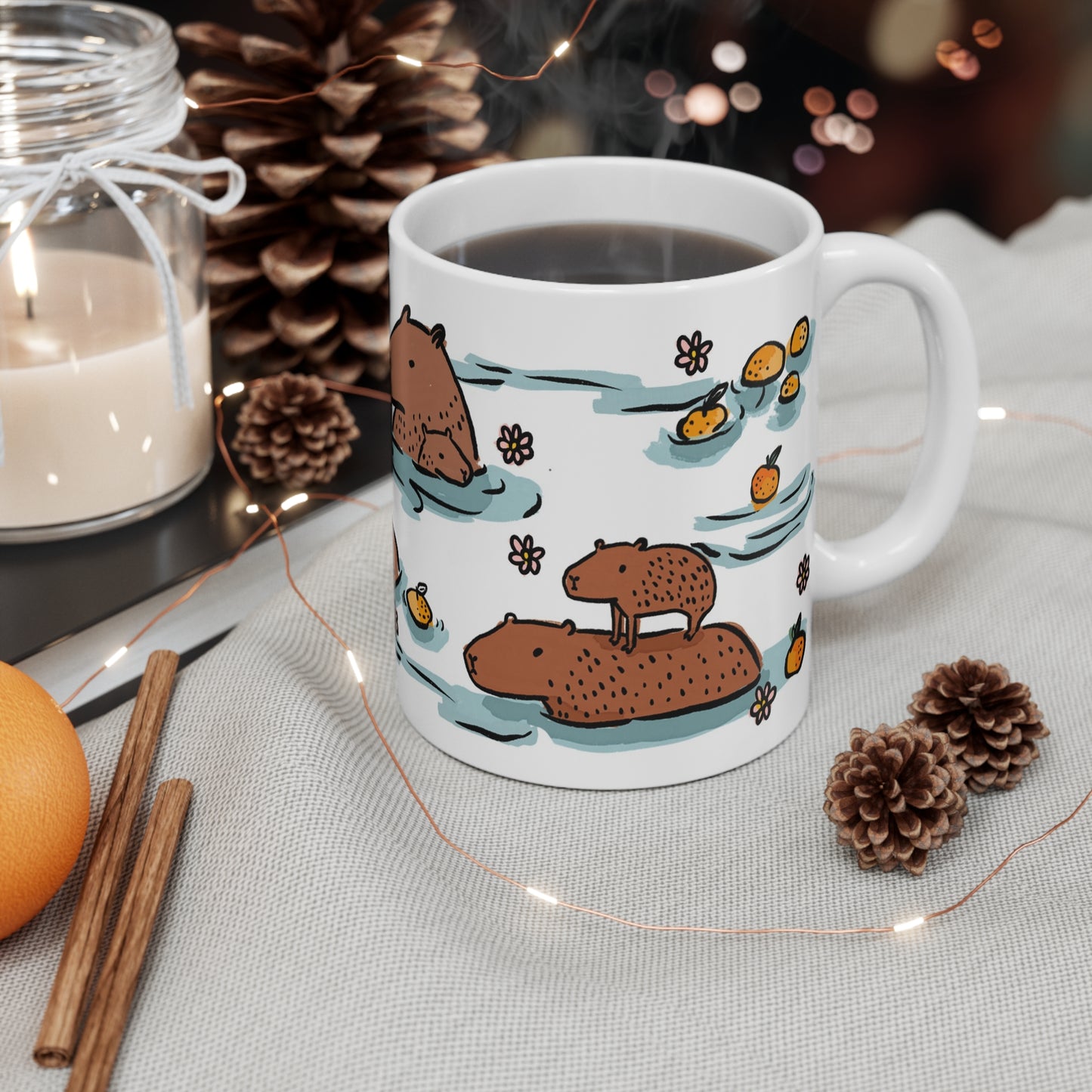 White ceramic mug featuring illustrated capybaras relaxing in a warm bath surrounded by floating oranges and flowers.