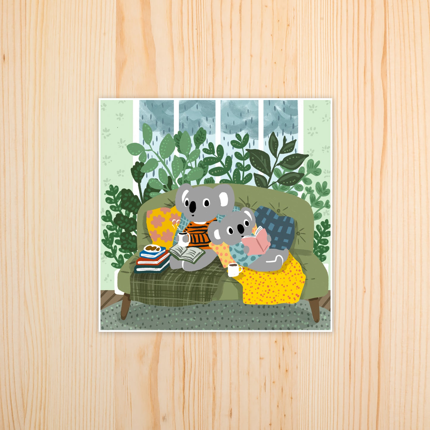 Two cozy koalas reading on a green couch surrounded by plants on a rainy day, illustrated art print by Miss Johnny Squirrel