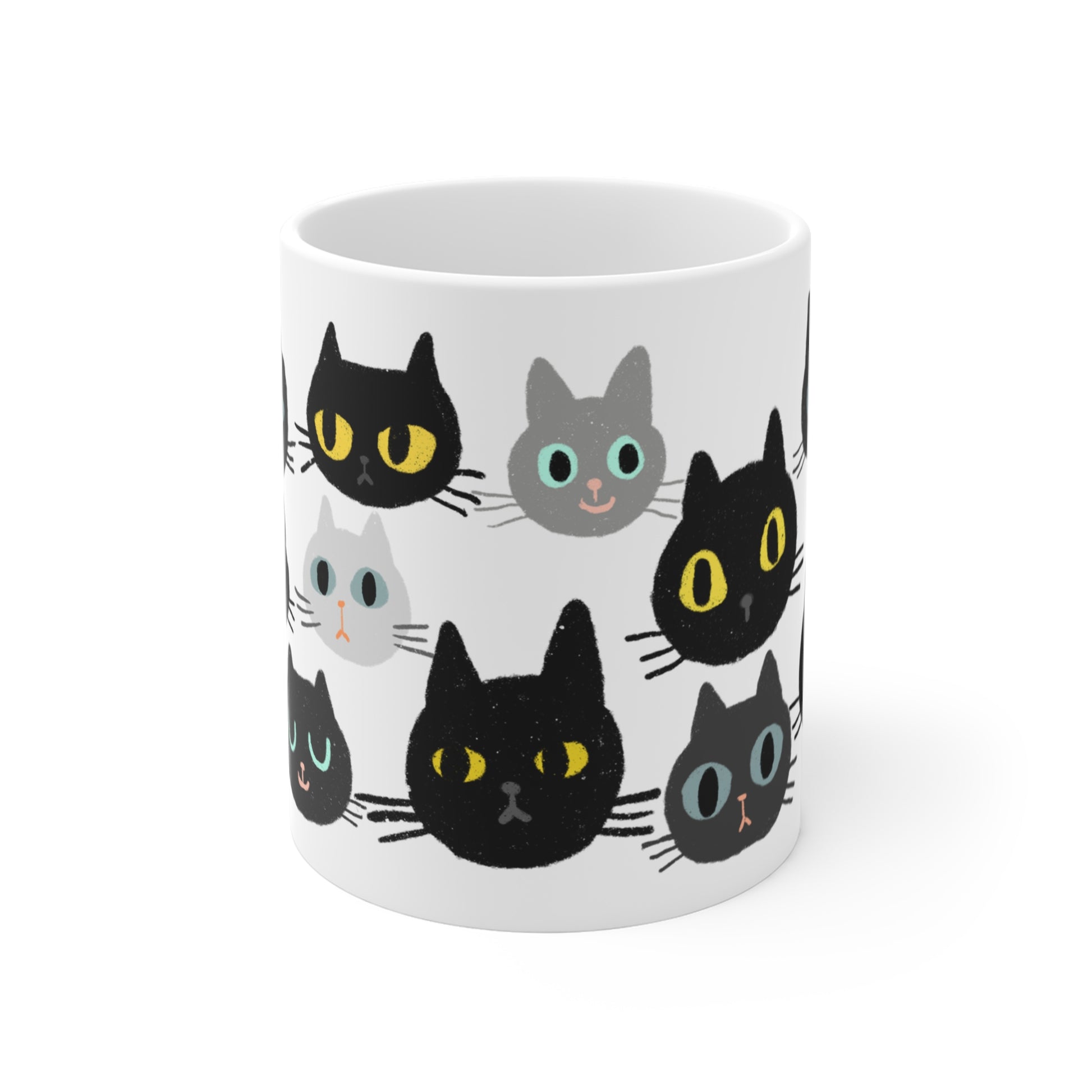 Ceramic mug featuring rows of illustrated cat faces in black, gray, and white tones with playful, wide-eyed expressions.