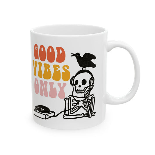 White ceramic mug featuring a skeleton DJ with headphones, a bird on its head, and retro text reading “Good Vibes Only.”