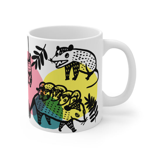 White ceramic mug with illustrated opossums, surrounded by colorful abstract shapes