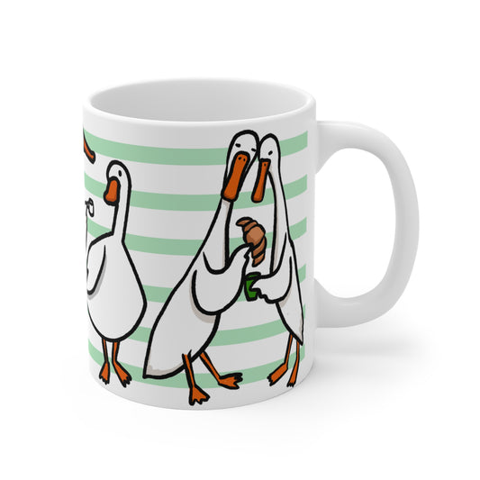 White ceramic mug featuring illustrated ducks drinking coffee, holding mugs, and sharing croissants on a green striped background.