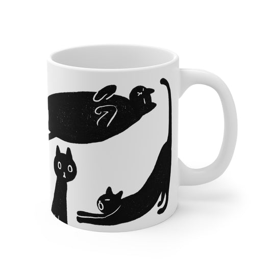 Black and white ceramic mug featuring illustrated black cats in various playful poses.