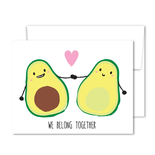 Greeting card with two illustrated avocado halves holding hands with a pink heart above, captioned “We Belong Together.”