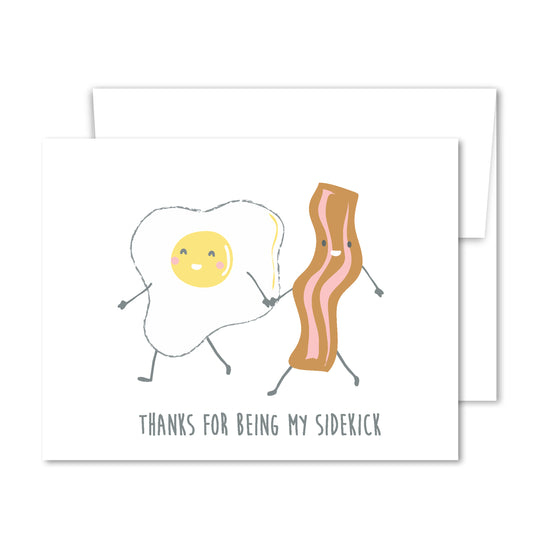 Greeting card featuring a smiling bacon strip and fried egg holding hands, whimsical illustration for friendship or appreciation.