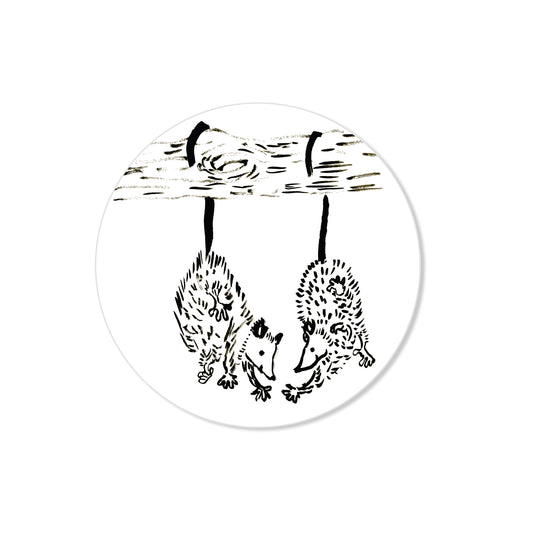 Opossum friends sticker with two opossums hanging by tails from branch, hand-drawn circle illustration