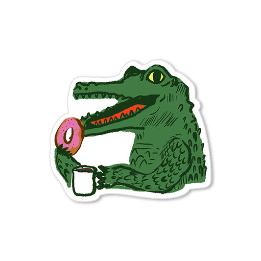 Coffee and donut gator sticker with green alligator holding mug and pink donut, humorous hand-drawn illustration