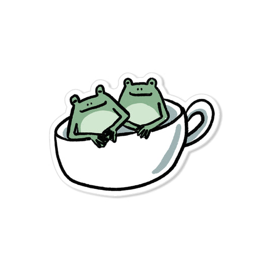 Frog cup sticker with two green frogs sitting in a teacup, hand-drawn cozy illustration