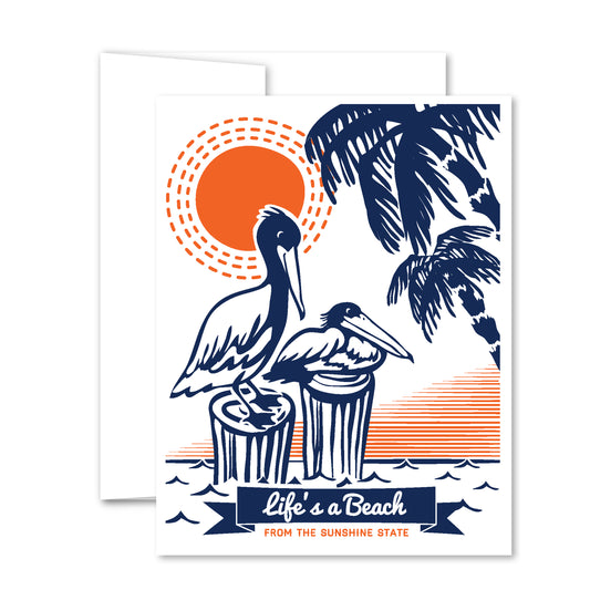 Illustration of two pelicans on posts with palm trees and bright orange sun, reading “Life’s a Beach” in a Florida-inspired greeting card.