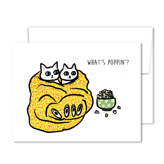 Illustrated two white cats wrapped in a yellow blanket with a bowl of popcorn, “What’s Poppin’?” friendship greeting card